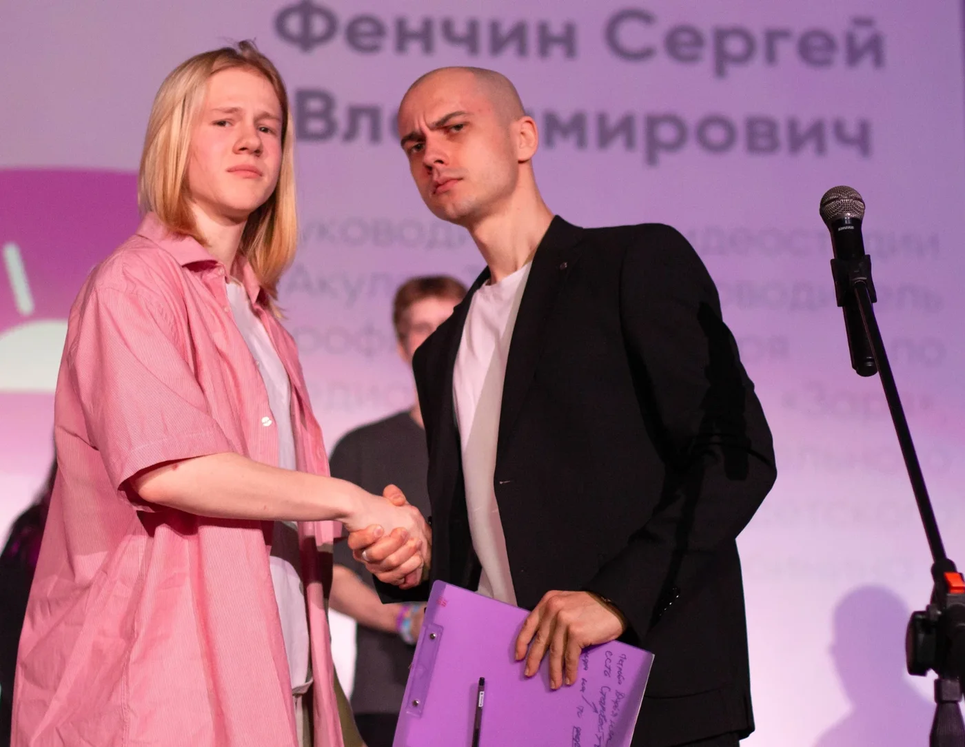 Сергей Фенчин пожимает руку ученику на сцене во время награждения